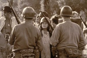 A young female protester wearing a helmet faces down helmeted and armed police officers at an anti-Vietnam War demonstration outside the 1968 Democratic National Convention, Chicago, Illinois, August 1968. (Photo by Hulton Archive/Getty Images)